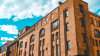 industrial brick building complex with white clouds in the background industrial brick building complex with white clouds in the background