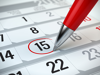 Red pen marking day of the month on a calendar
