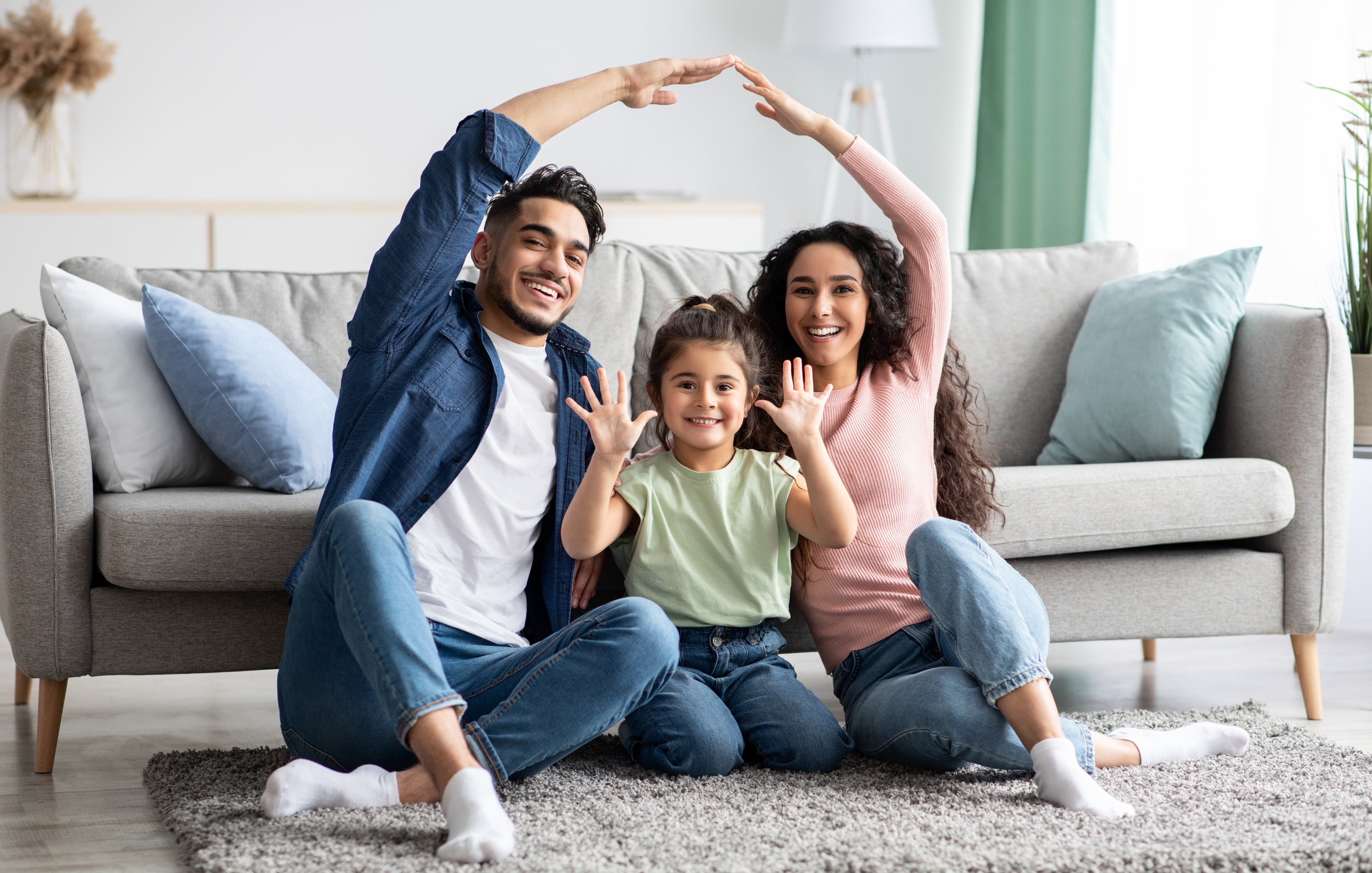 Arabic parents making symbolic roof of hands above their cute little daughter