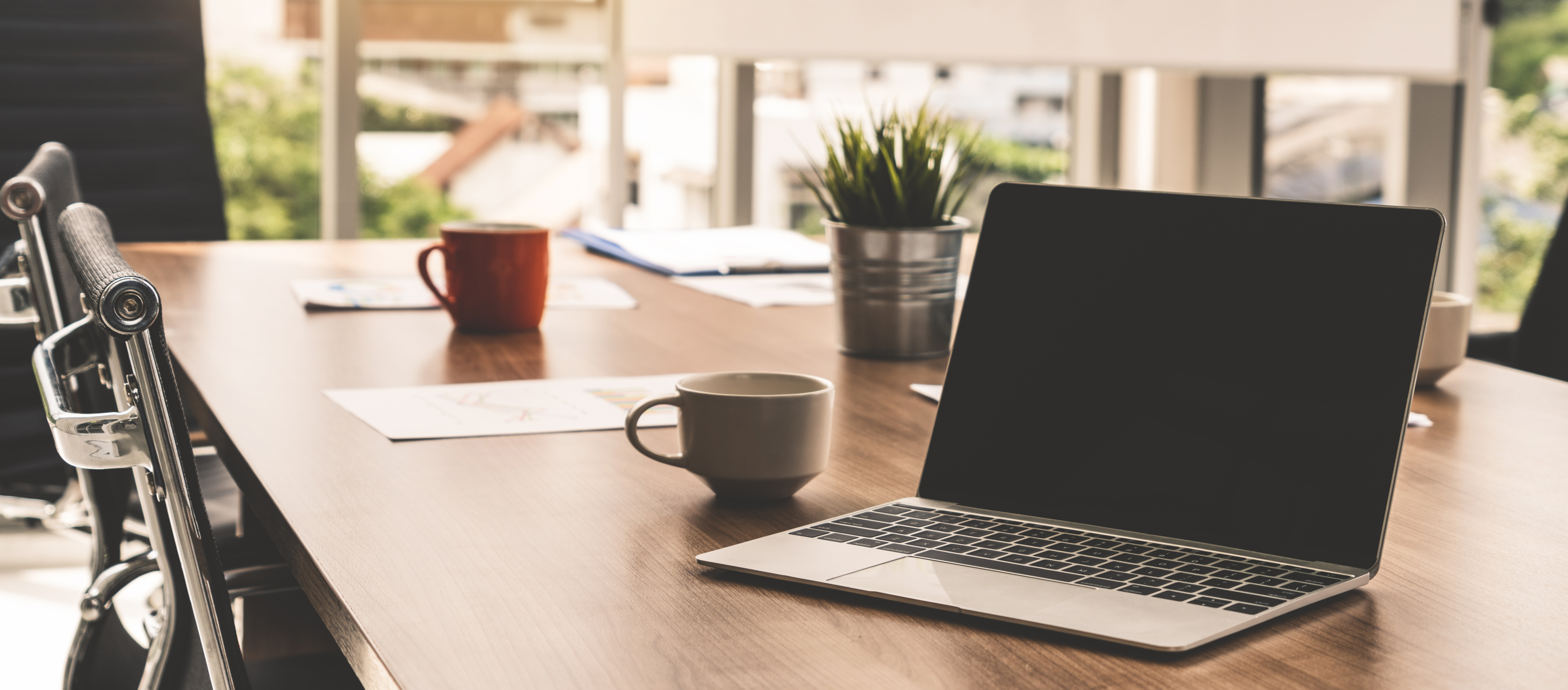 Laptop-Computer mit geöffnetem Deckel auf dem Tisch im Besprechungsraum eines Büroarbeitsplatzes
