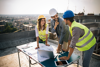 Eine Gruppe von Ingenieuren, Architekten und Geschäftspartnern arbeitet auf der Baustelle zusammen Eine Gruppe von Ingenieuren, Architekten und Geschäftspartnern arbeitet auf der Baustelle zusammen