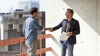 Two men on construction site shaking hands Two men on construction site shaking hands